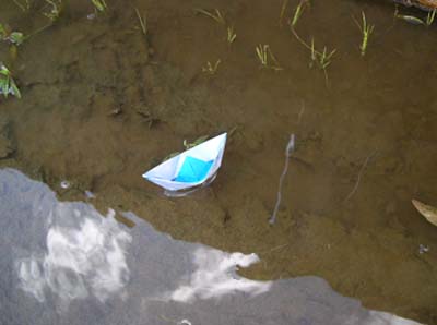origami boat floating in the river