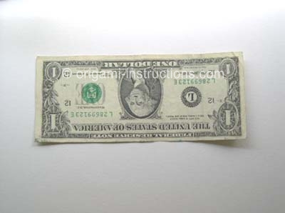dollar bill ready to fold into origami elephant